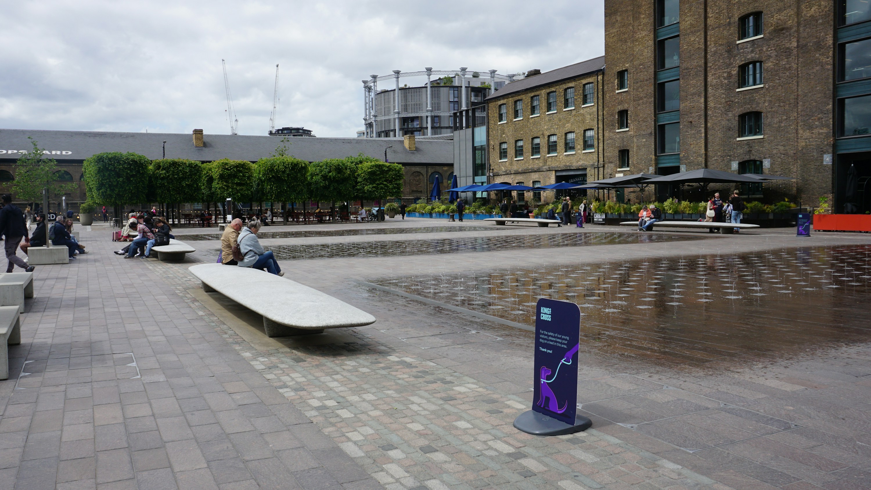 People relaxing in the modern public spaces of Coal Drops Yard at King’s Cross.