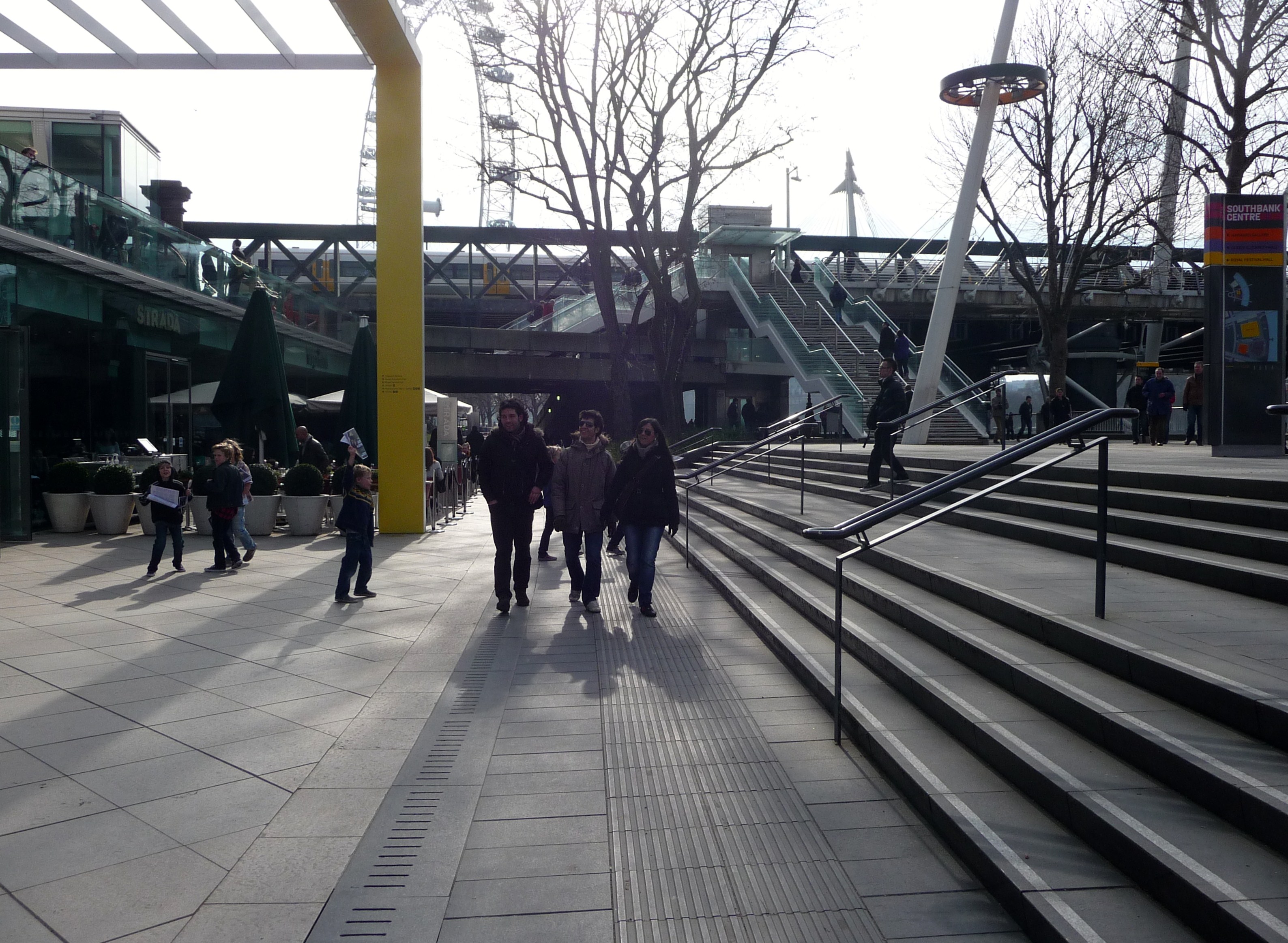 People walking beside the Thames on London’s South Bank.